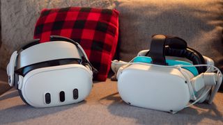 A Meta Quest 2 and Meta Quest 3 headset on a couch with a checkered pillow in the background