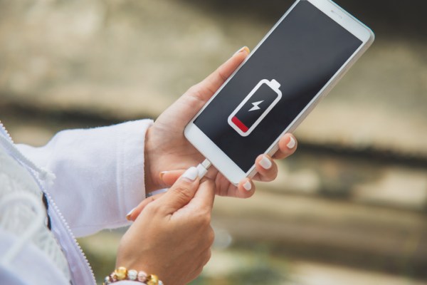 Close up of a woman charging her mobile phone with the charging symbol